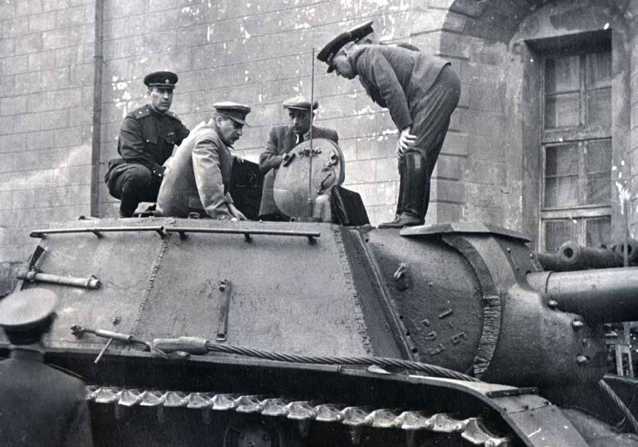 И.В. Сталин с группой военных осматривает самоходную артиллерийскую установку СУ-122 и другие образцы новой военной техники возле здания Арсенала. 1943 года